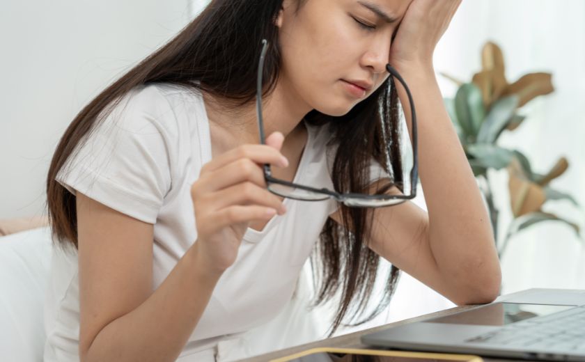 Woman holding an eye drop bottle, treating eye irritation from salt water exposure in Zakynthos